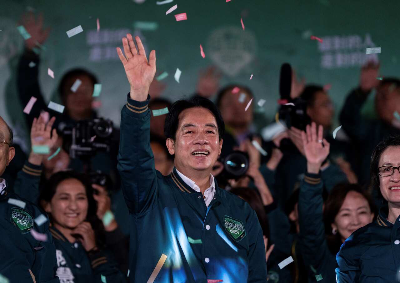 A man waves with colourful paper confetti raining down on him.