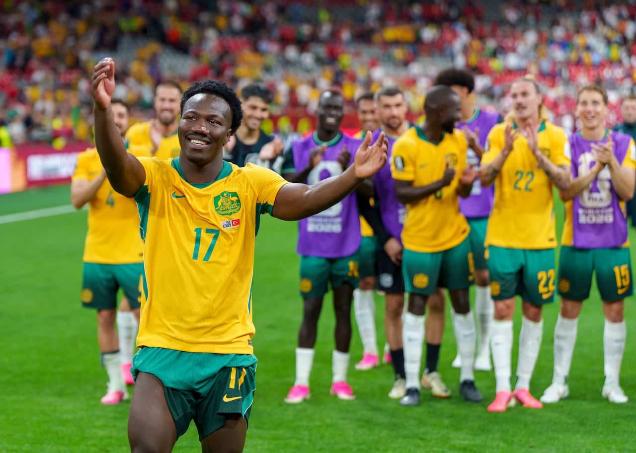 Football players in gold jerseys celebrating after winning a match