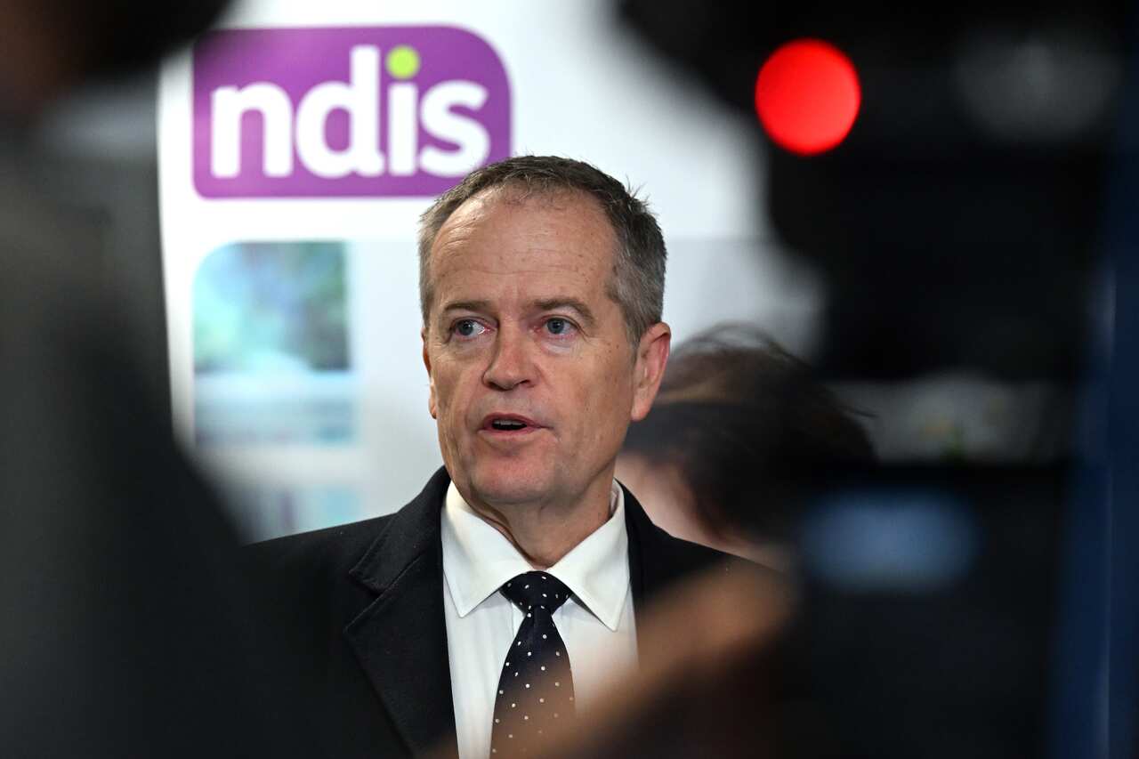 Bill Shorten speaking in front of an NDIS sign