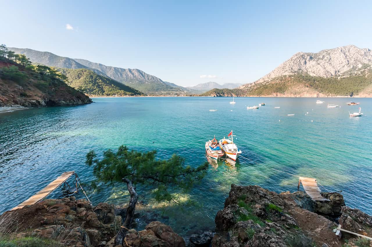 Boats in the water overlooking mountains. 