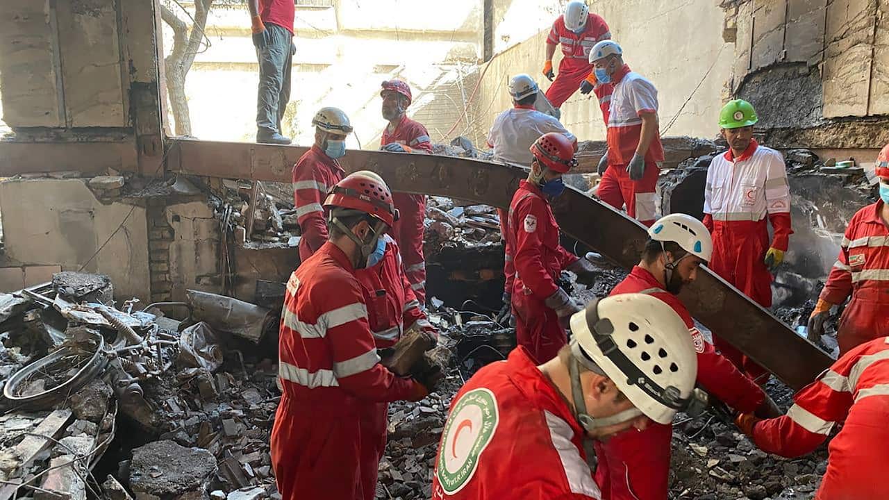 Rescue workers at the site of a building that has been destroyed.