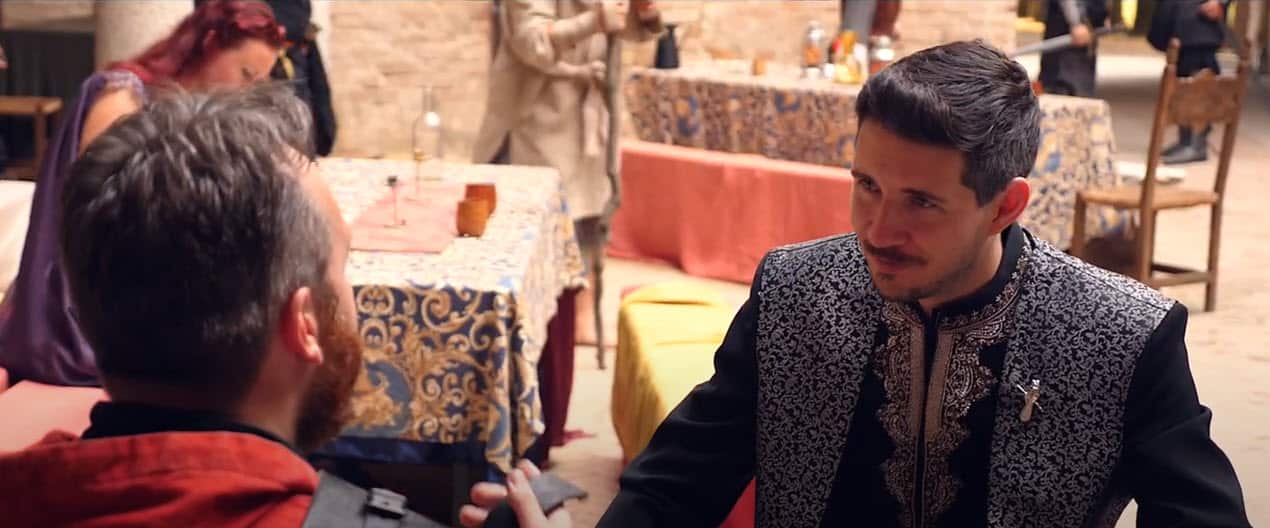 A man dressed up in old-fashioned formal wear faces another man