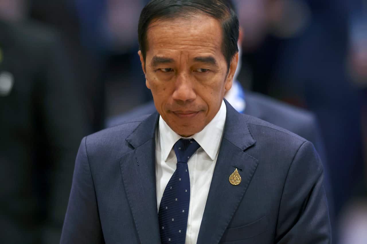 A man wearing a suit and tie walking.