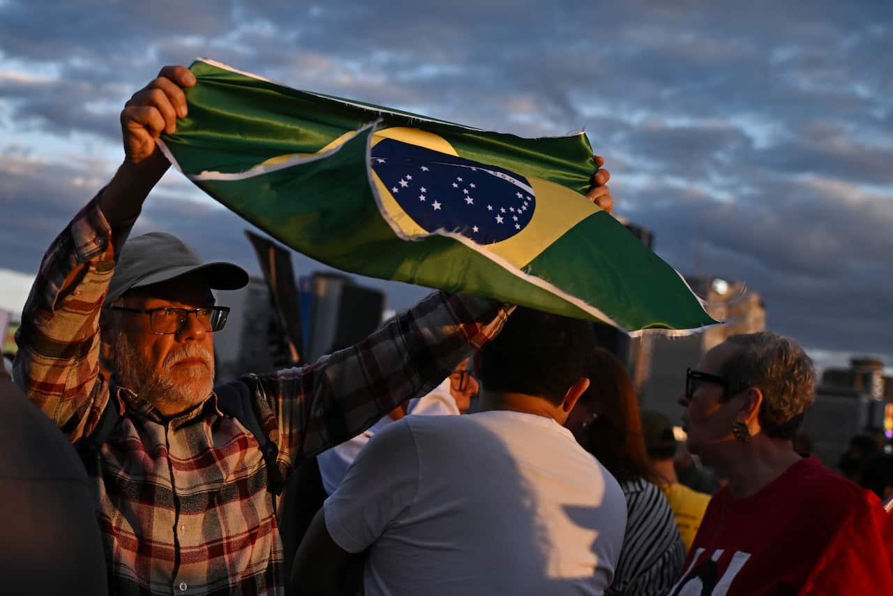 A man waves a Brazilian flag at a protest.