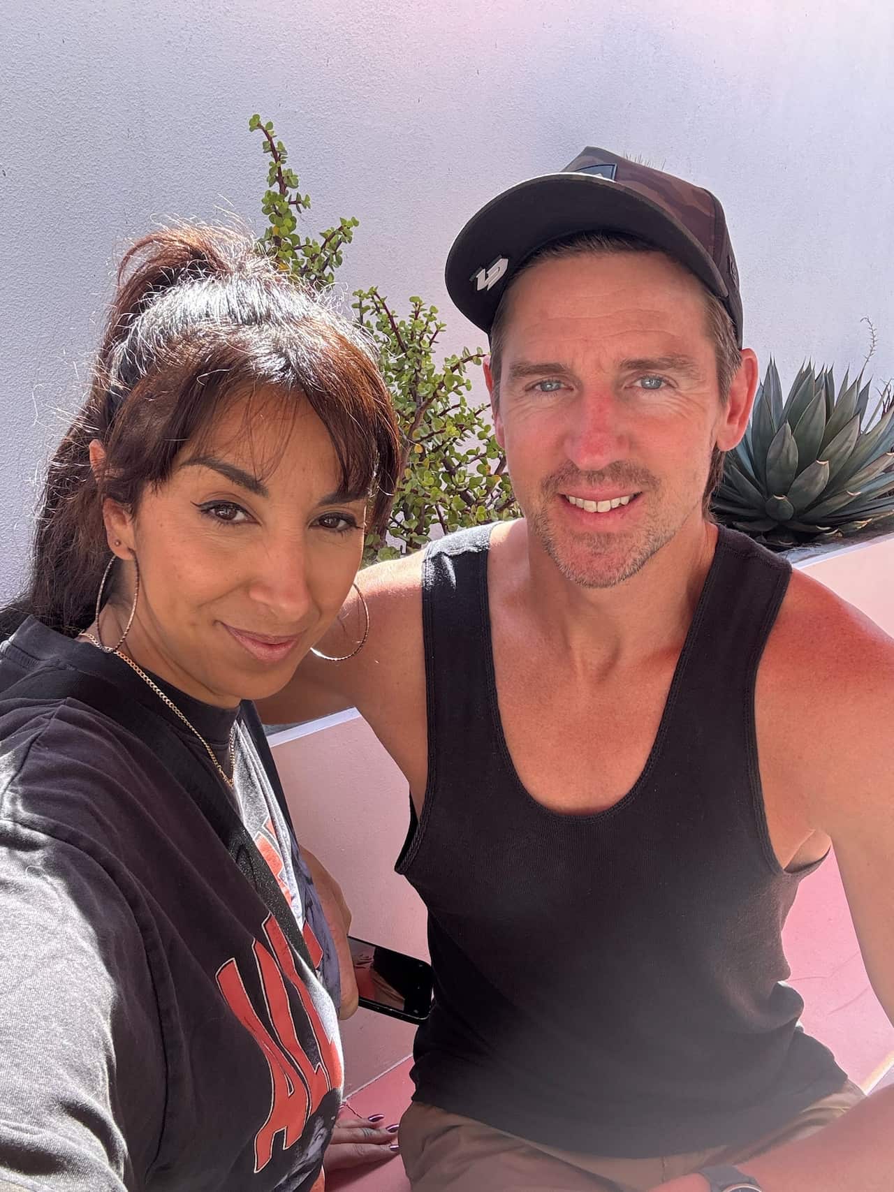 A couple sit together and smile slightly at the camera.