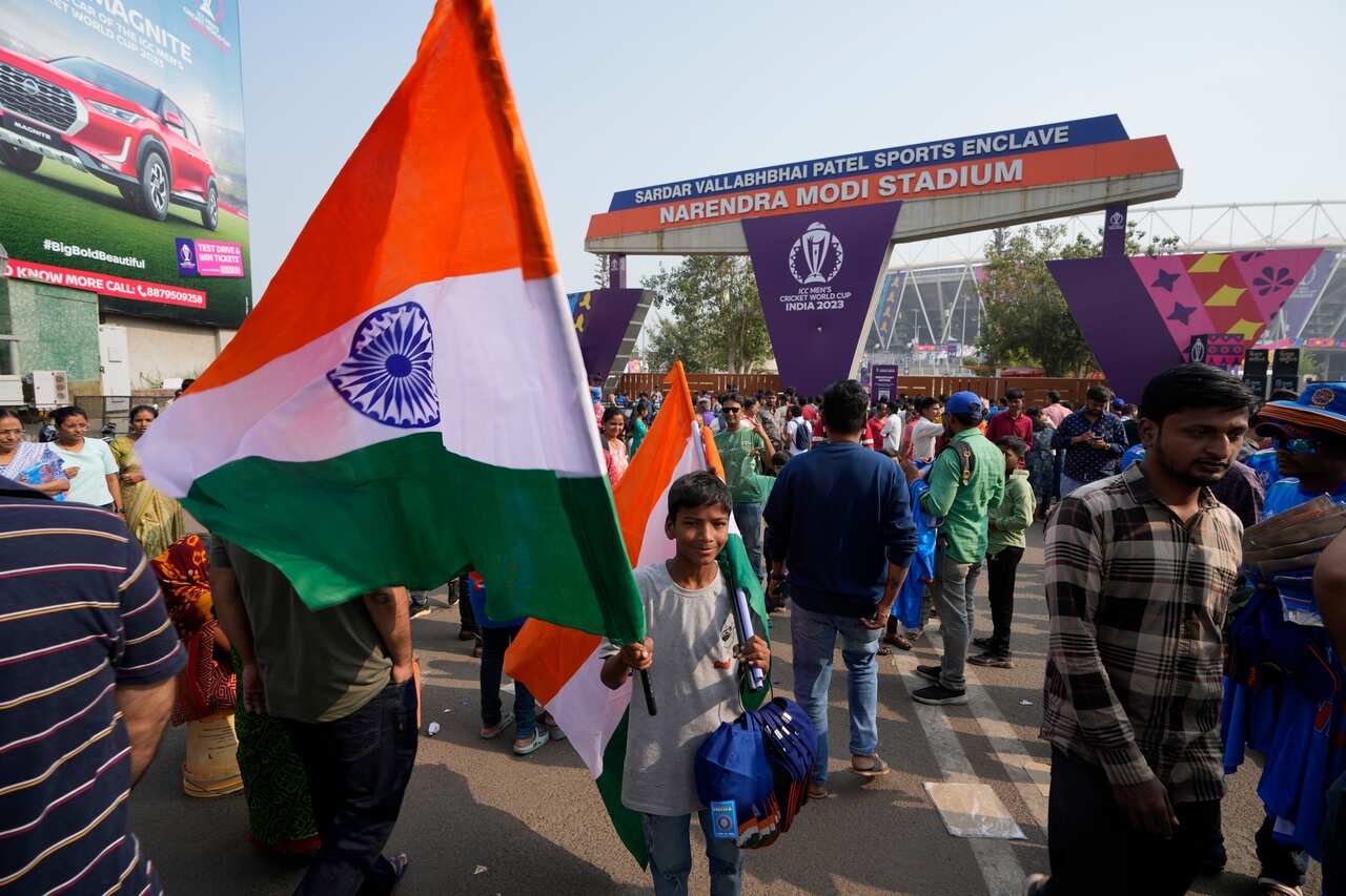 A young boy holds an Indian flag outside Narendra Modi stadium