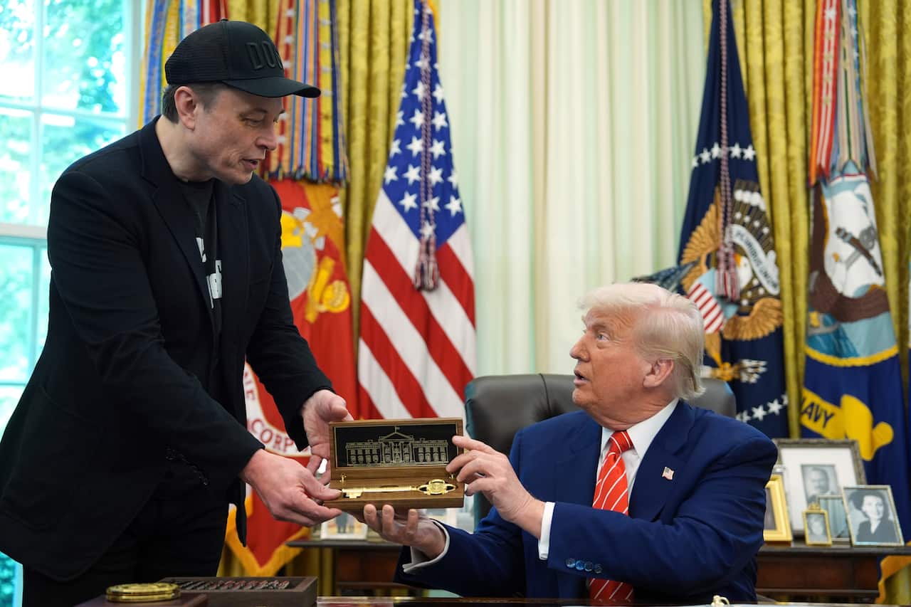 US President Donald Trump handing billionaire Elon Musk a symbolic key.