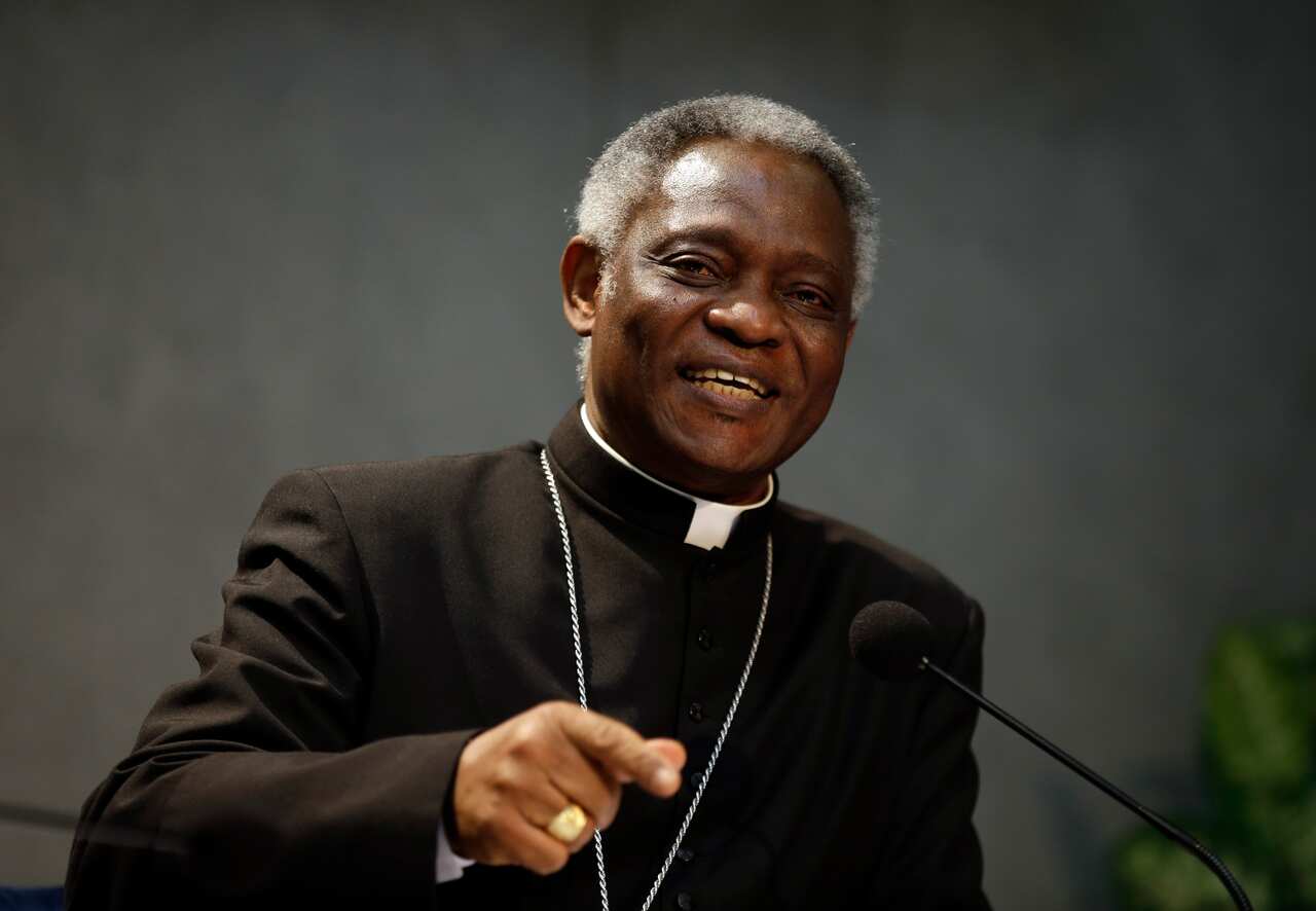 A man in Catholic robes is smiling. 