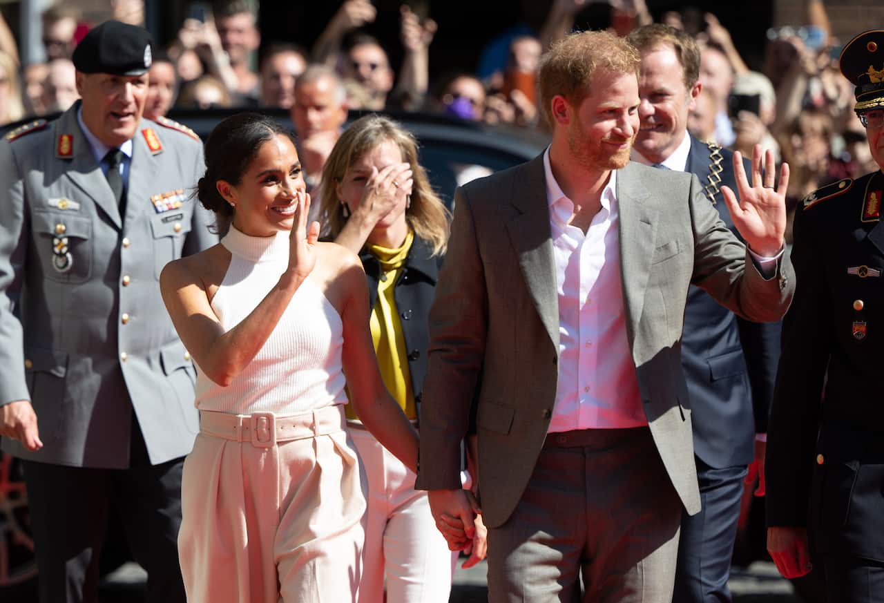 Prince Harry and Meghan wave to crowds.