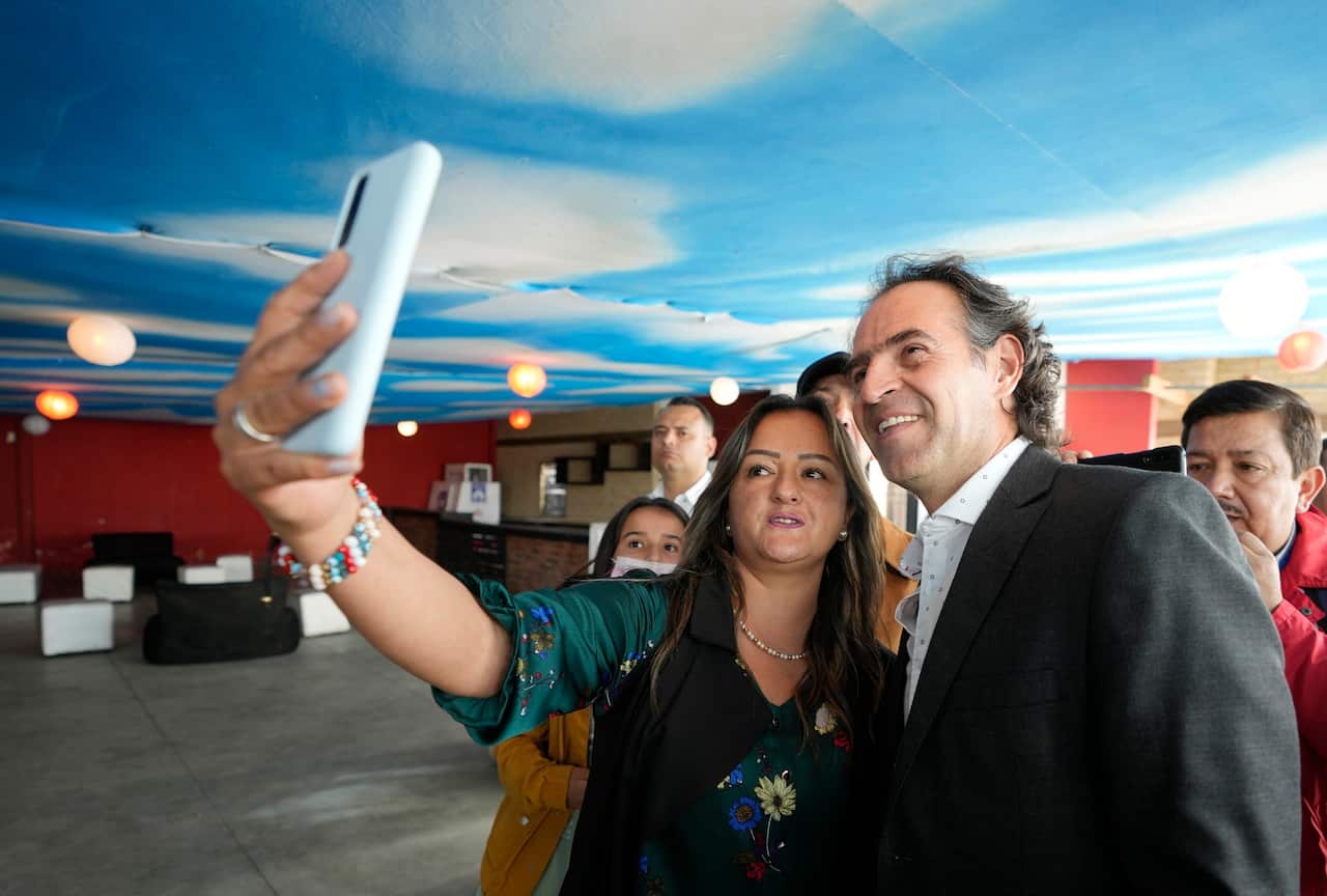 Presidential candidate Federico Gutierrez poses for a selfie with a supporter during a campaign rally in Chia, Colombia, Monday, May 16, 2022.