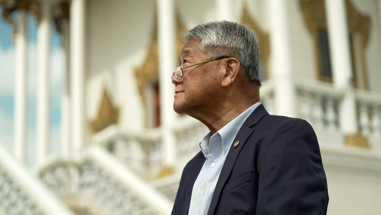 A man wearing glasses and a suit.