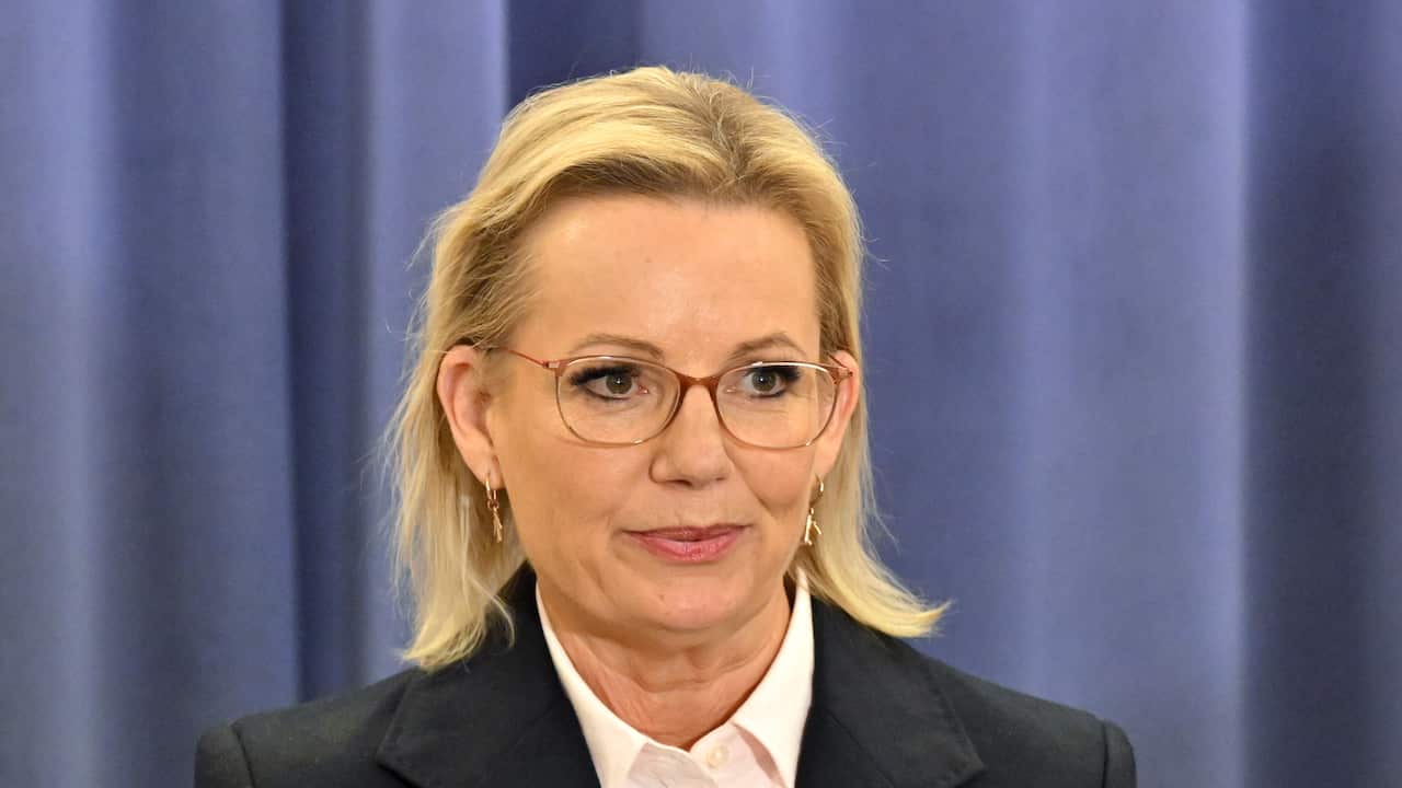 Sussan Ley standing in front of a blue curtain.