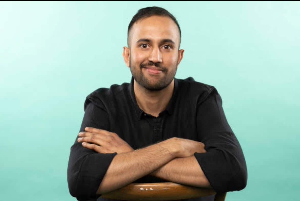 Shashank Achuta in a black top looking at camera, crossing arms