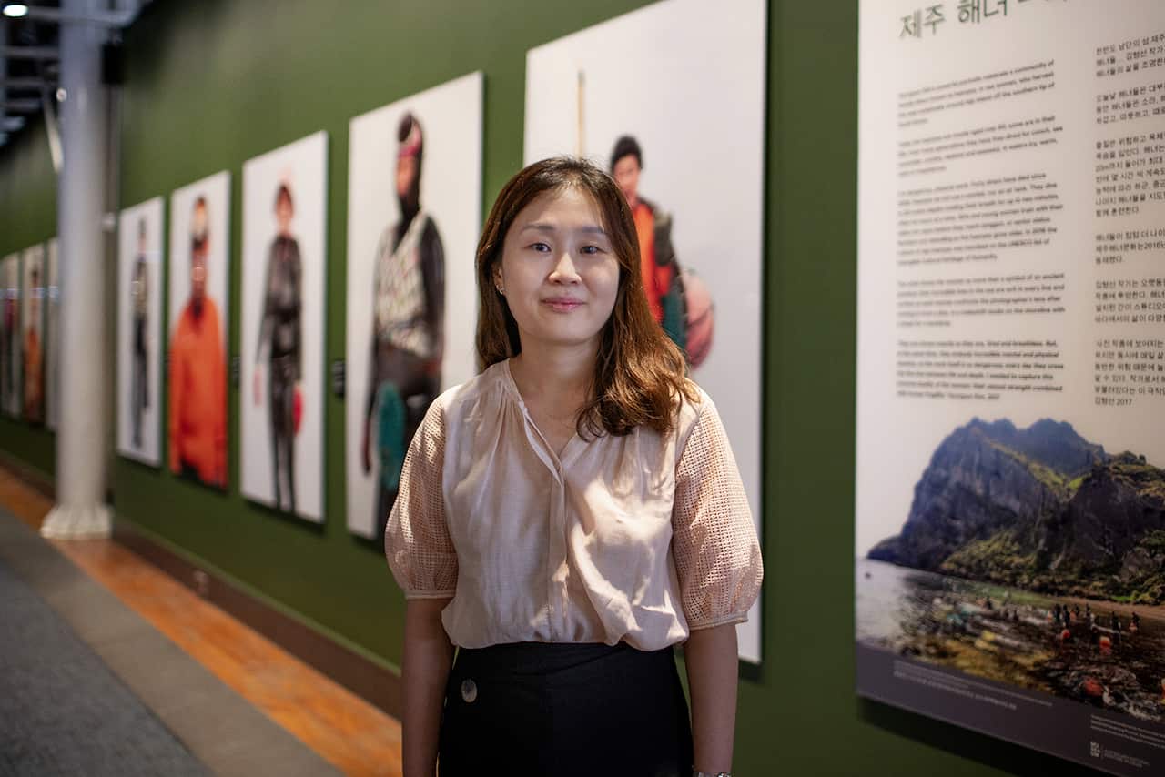 A woman standing in front of some artworks