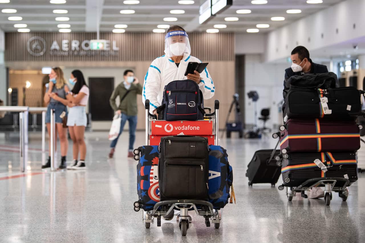 Man walking through Sydney airport in PPE.