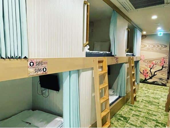 Bunk beds with sliding fabric curtains and small TVs above the beds.