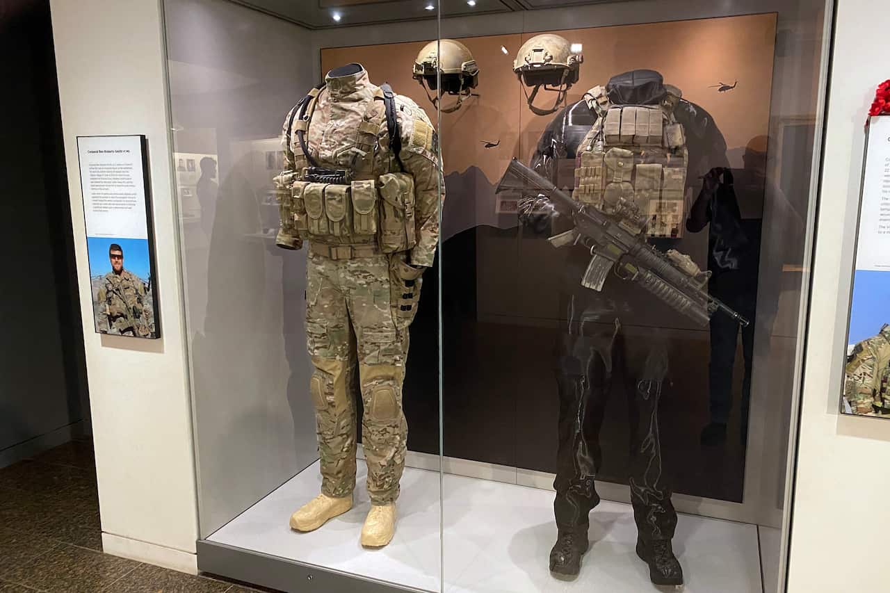 A glass display case with two army uniforms.