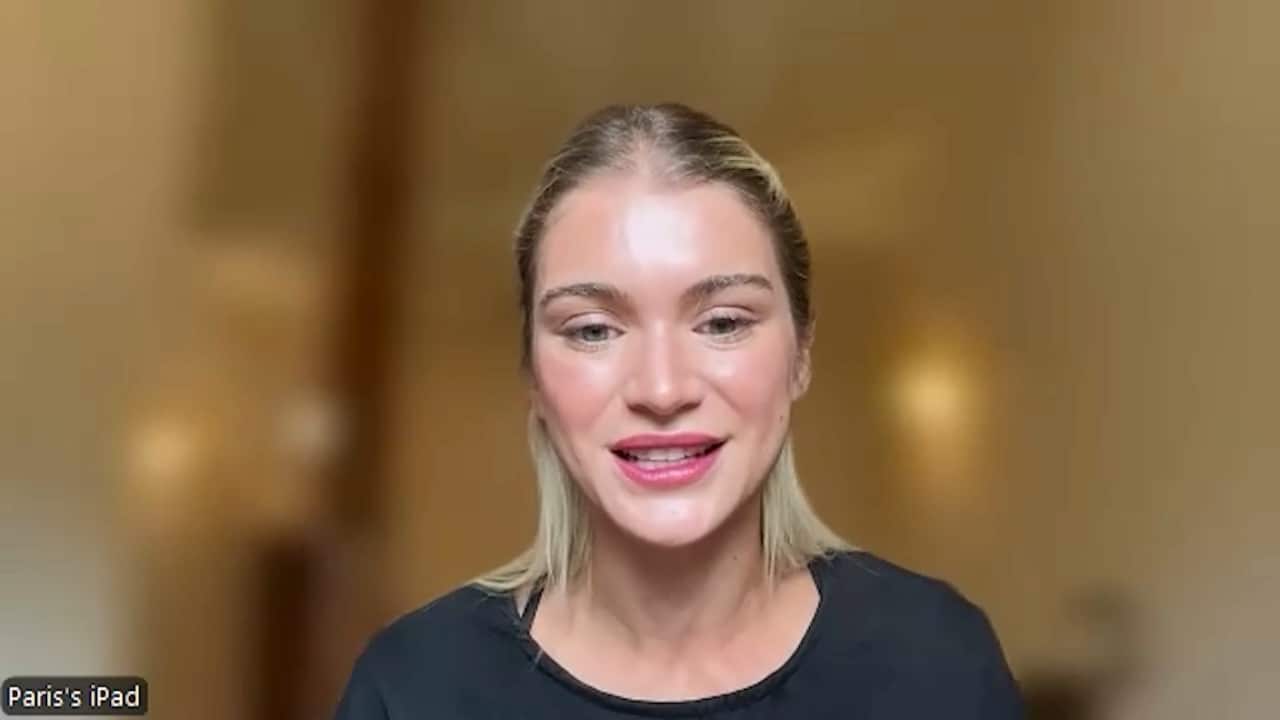 A young blonde white woman wearing a black top.