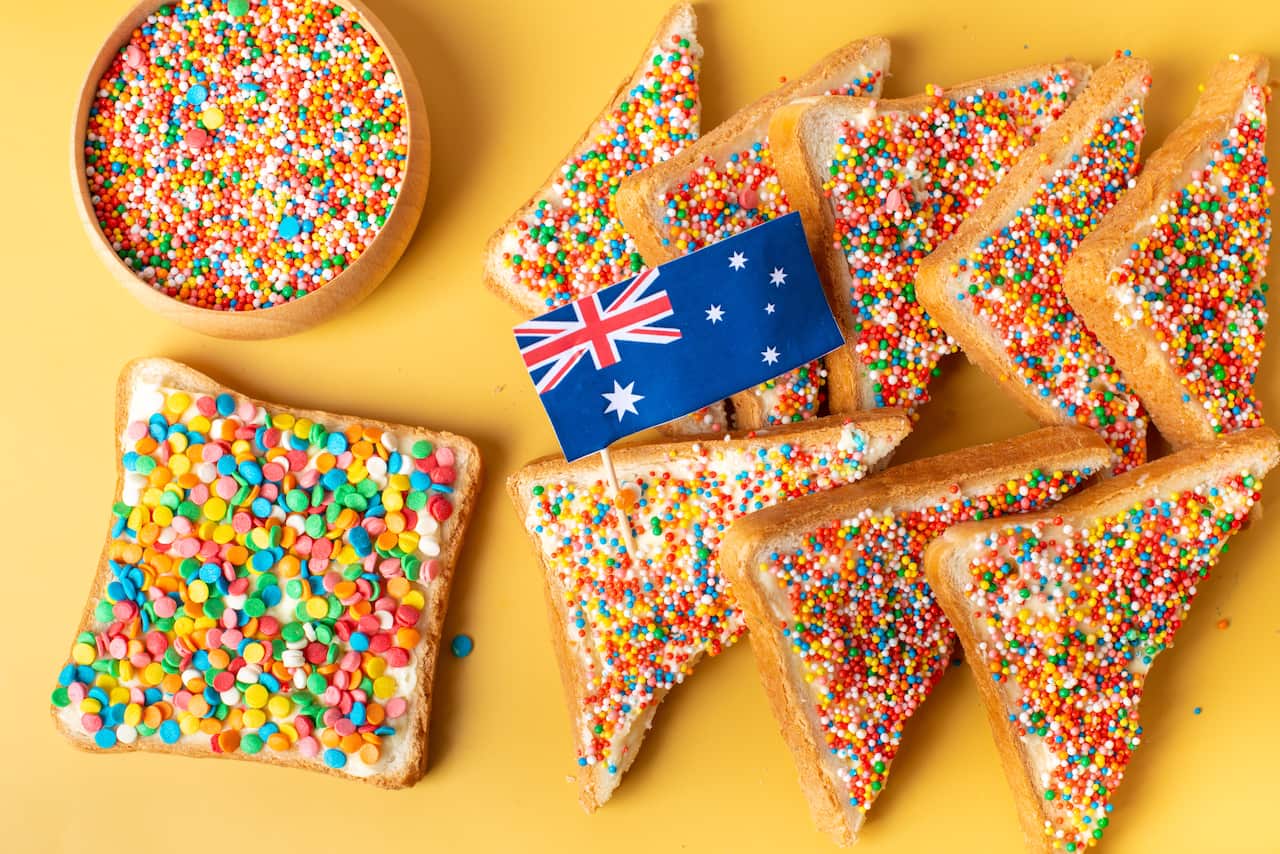 Fairy bread with butter knife, side view. The famous traditional Australian food Fairy Bread on a yellow background
