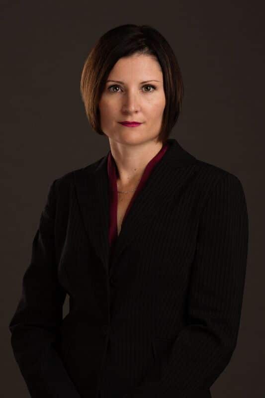 Sarah A woman wearing a black blazer.
