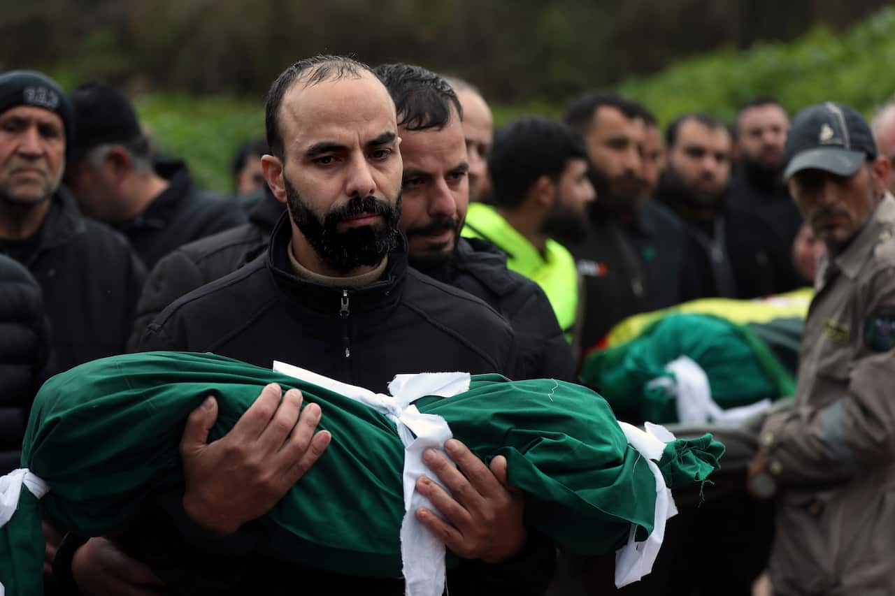 A man carries the shrouded body of his child killed in an Israeli airstrike