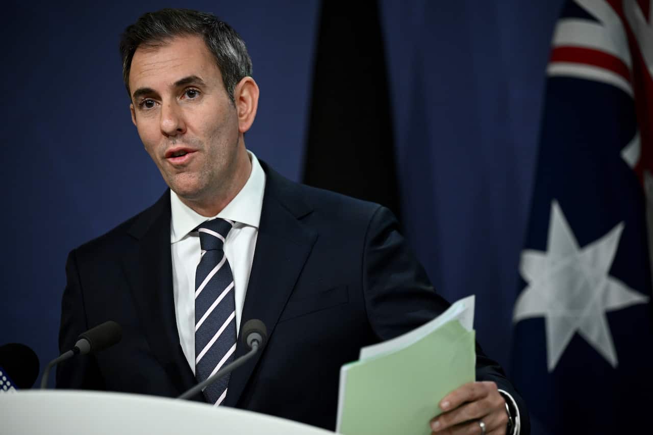 Jim Chalmers holding papers as he speaks to an audience.