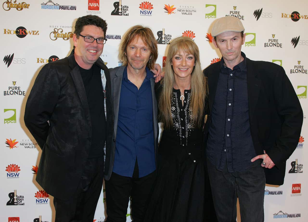 Three men and a woman pose for a photo at an award show