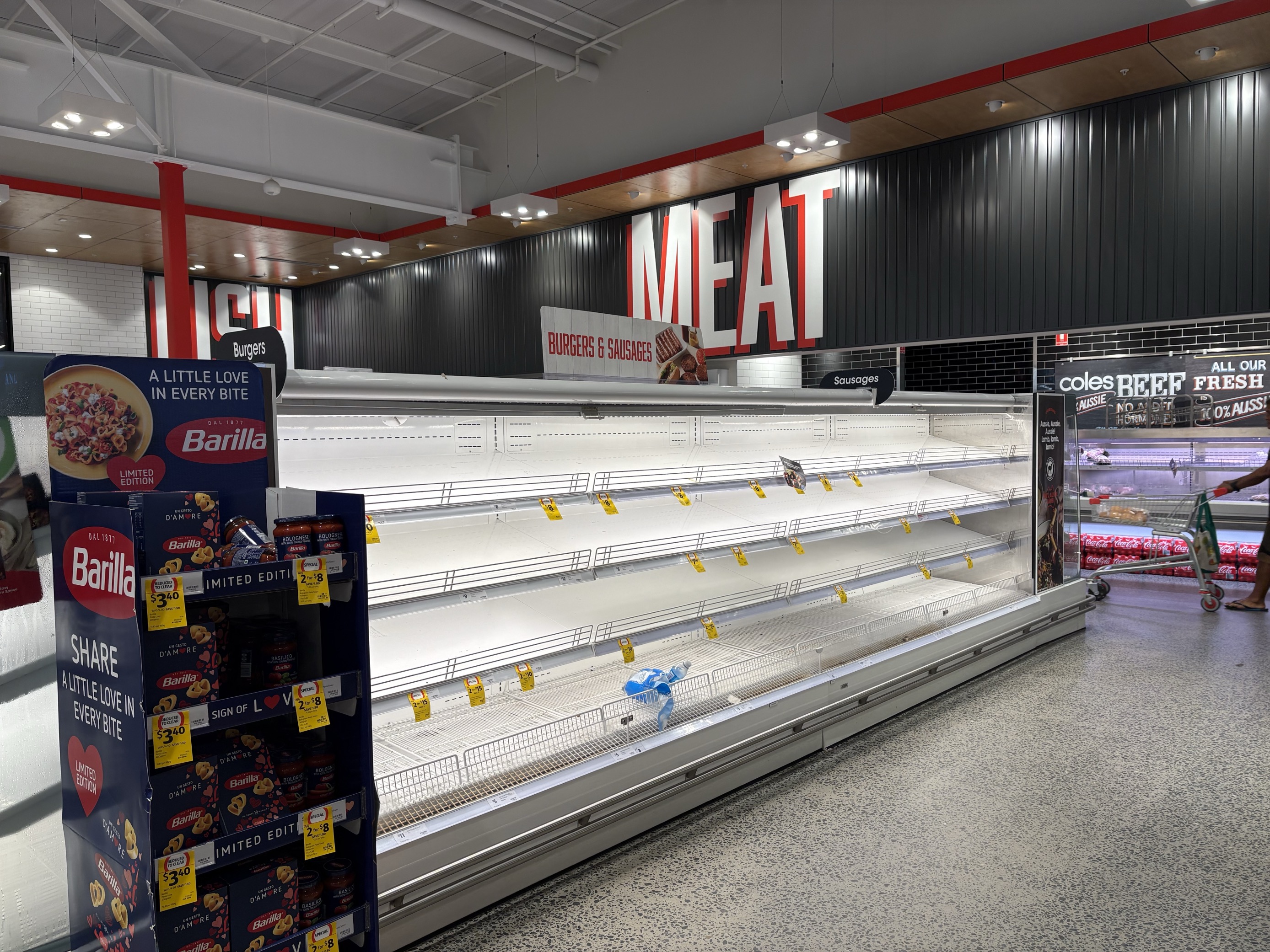 Empty shelves in the meat section of a supermarket.