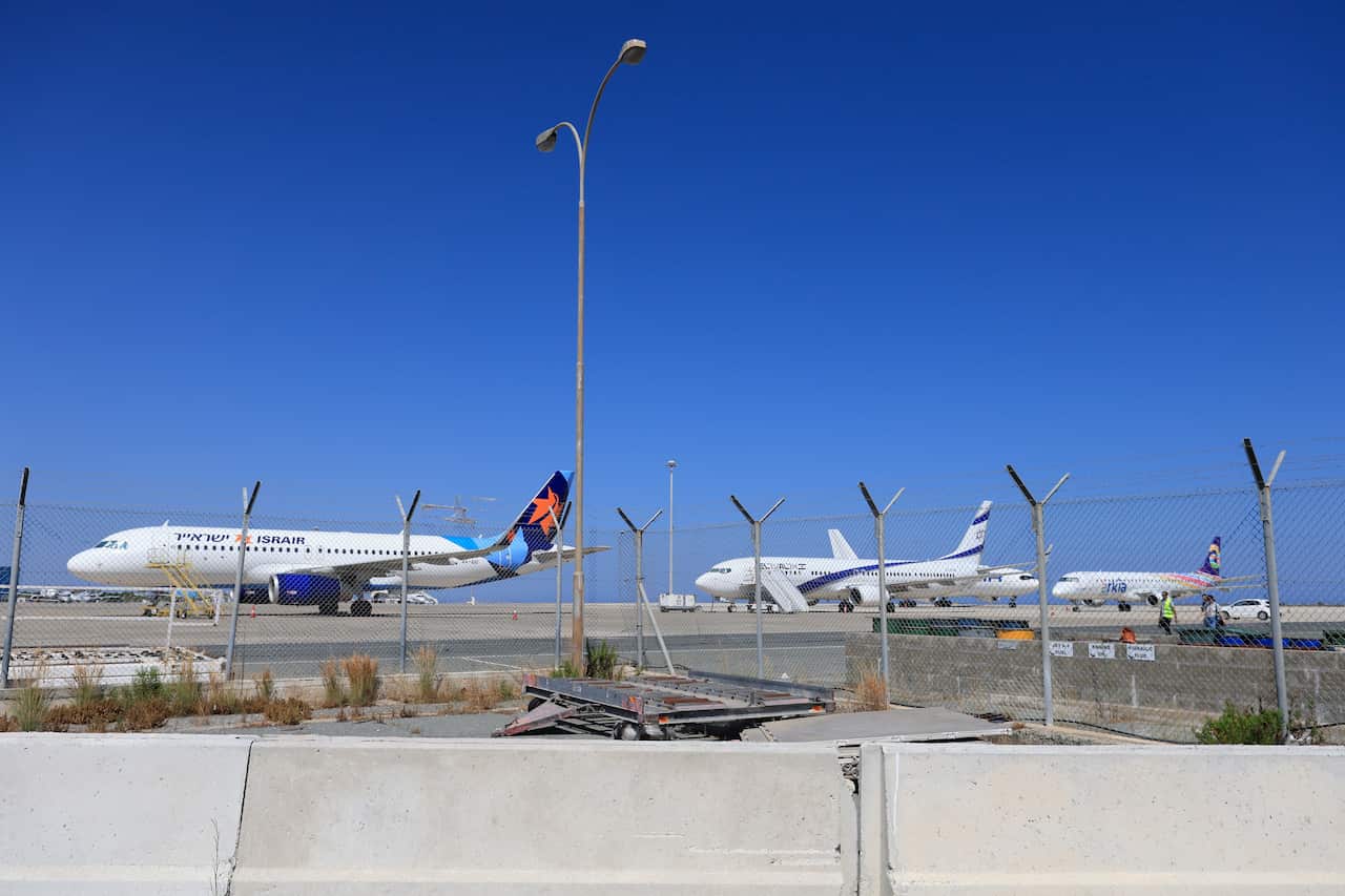 Penny Wong speaking at a lectern with the Australian, Aboriginal, and Torres Strait Islander flags behind her