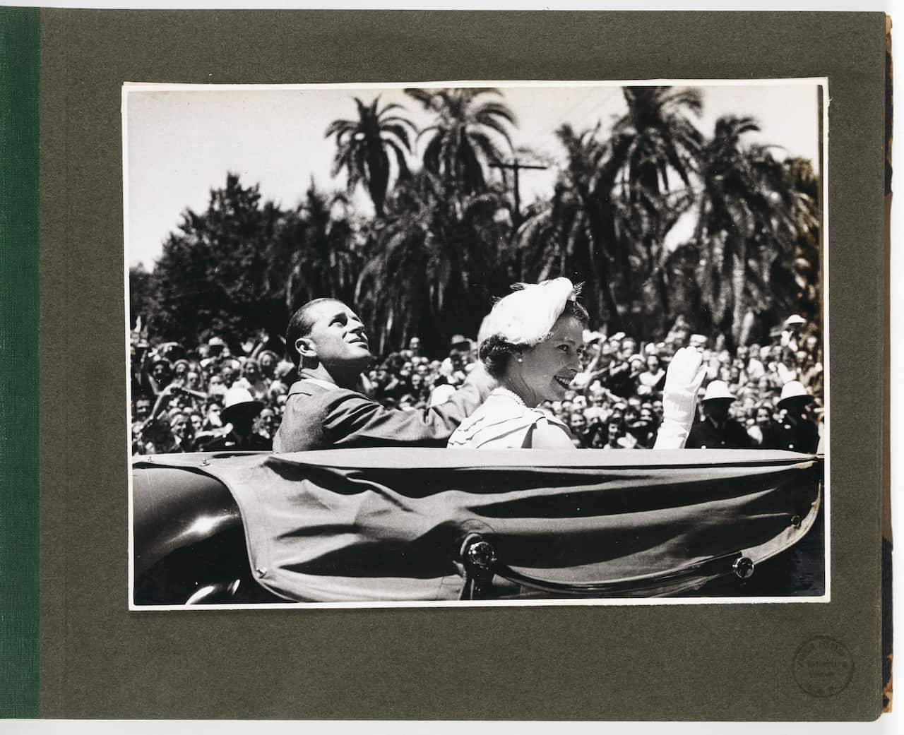 Queen Elizabeth and the Duke of Edinburgh sitting in a car waving to crowds in Australia