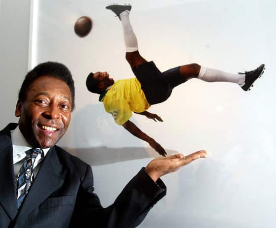 FILE PHOTO: Brazilian soccer legend Pele stands next to a photograph of him at the opening of the 'Pele Collection' in the County Hall, London
