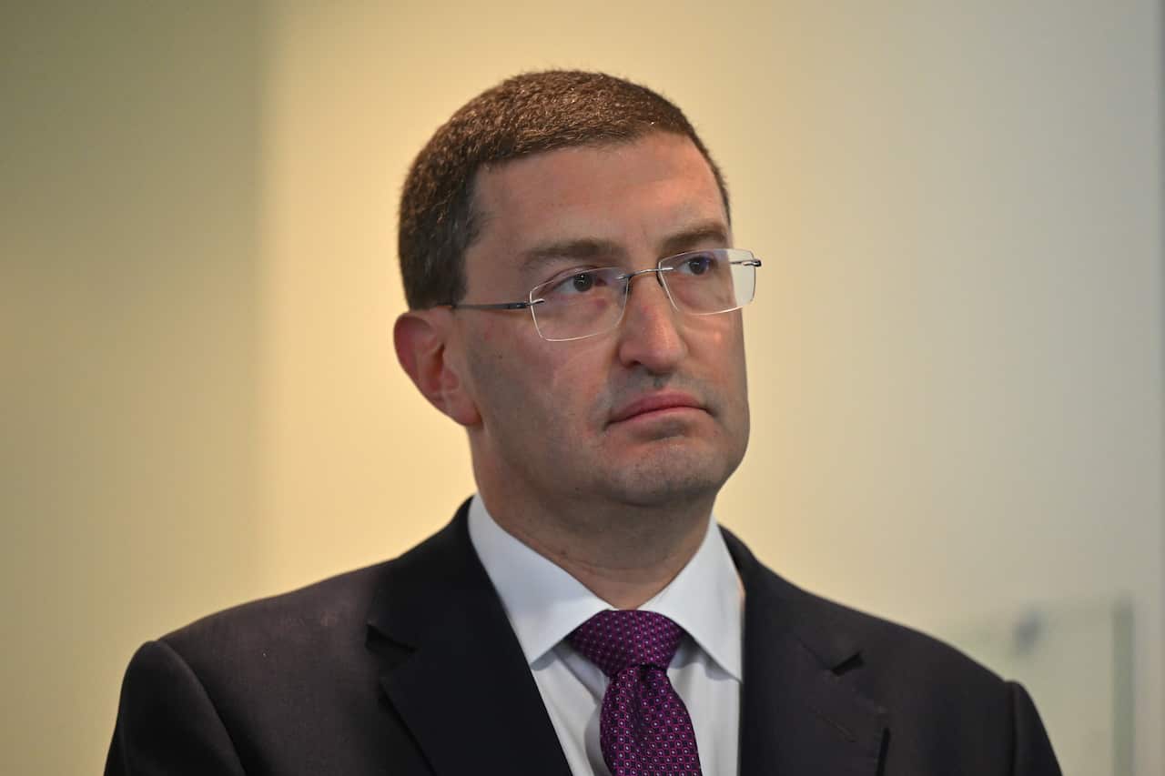 A man wearing a suit, tie and glasses.