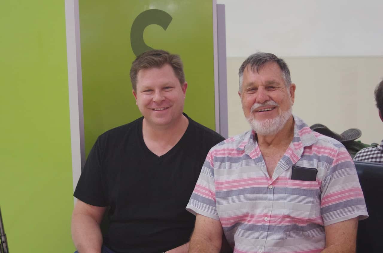 Andrew and Gary sitting next to each other in Cairns airport.