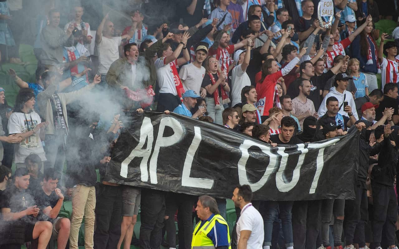 Melbourne City fans hold signs expressing disapproval of the APL's decision on the A-League grand final.