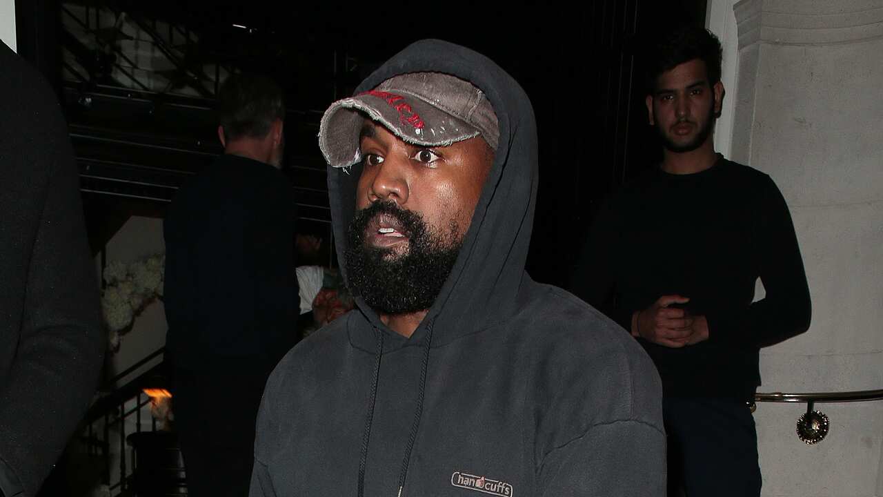 Kanye West wearing a hoodie and cap.