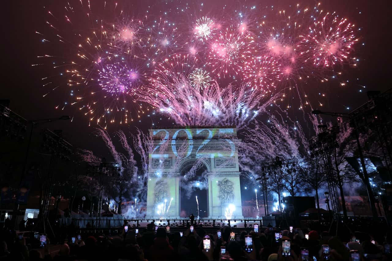 Fireworks illuminating the sky around the Arc de Triomphe in Paris.