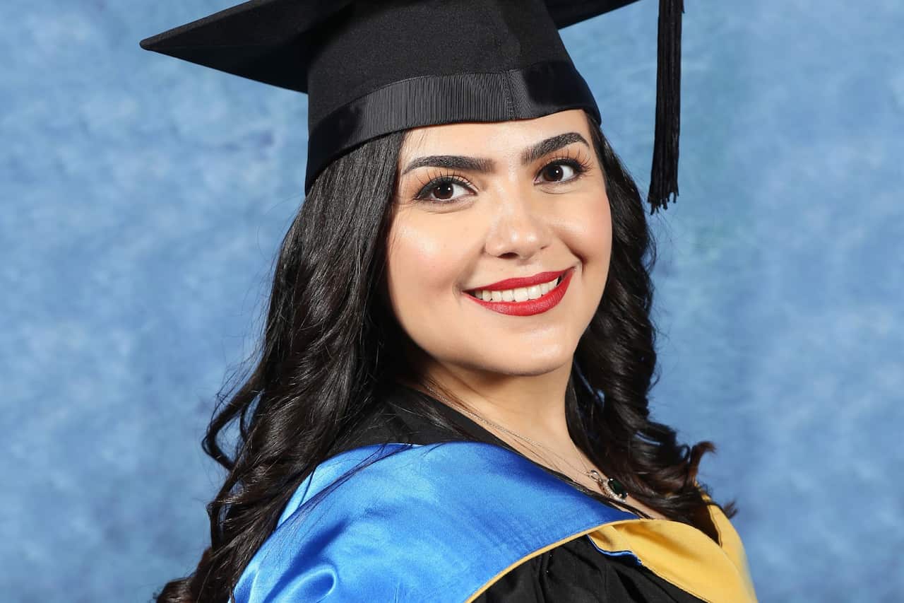A young woman wearing a graduation cap and gown