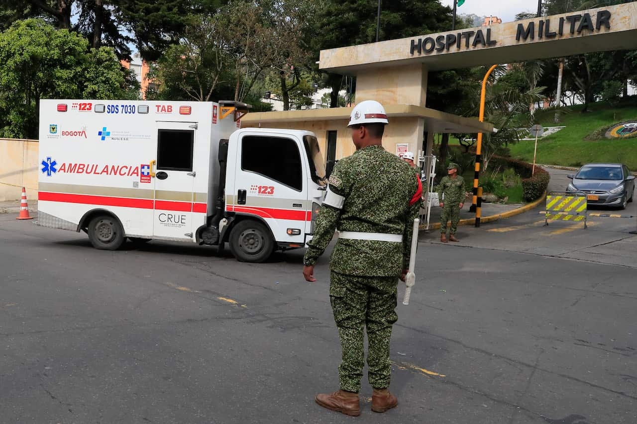 An ambulance driving through a hospital entry gate.