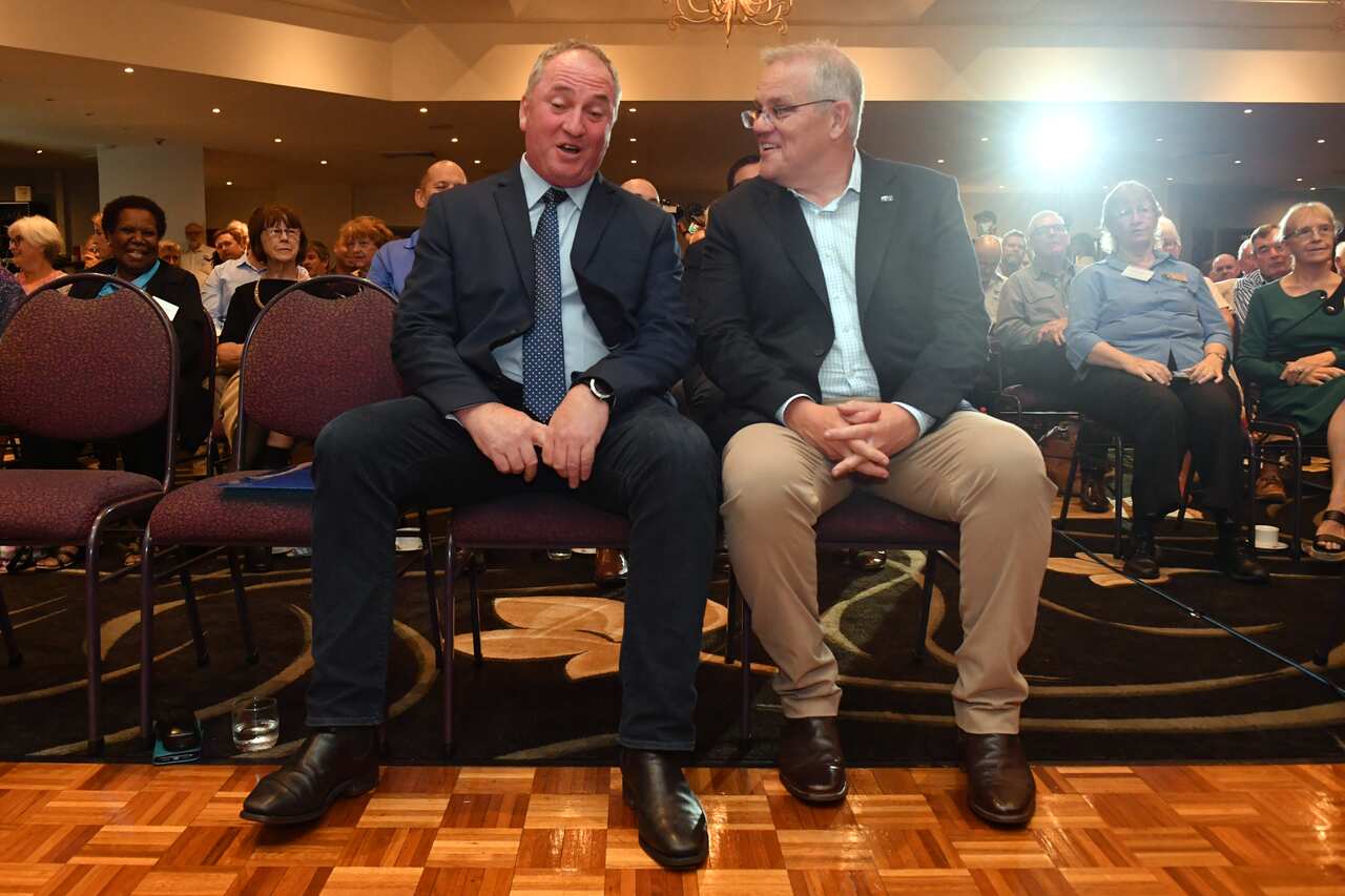 Two men speaking while sitting down.