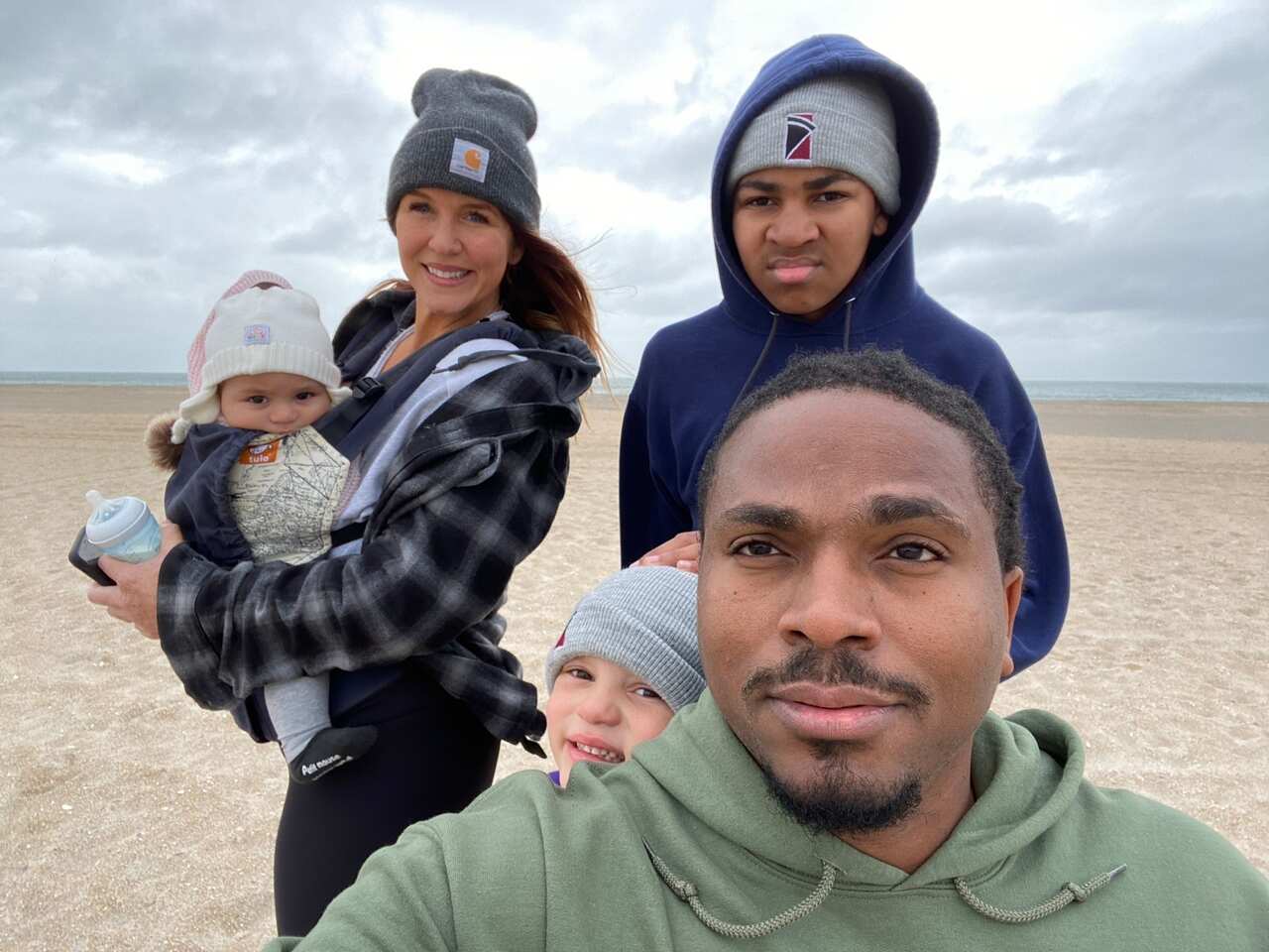 A photo of a family dressed in warm clothes at the beach.