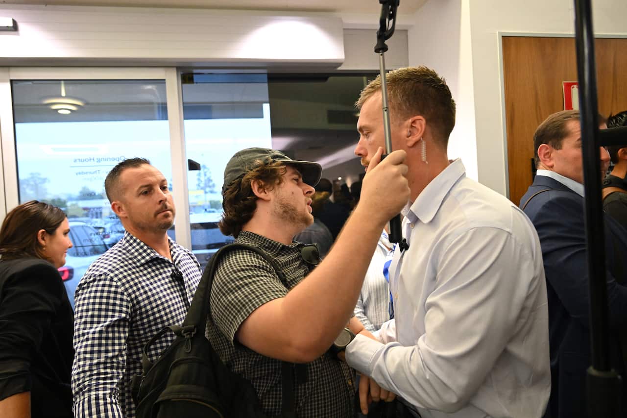 A man holds a pole as he is pushed back by another man.