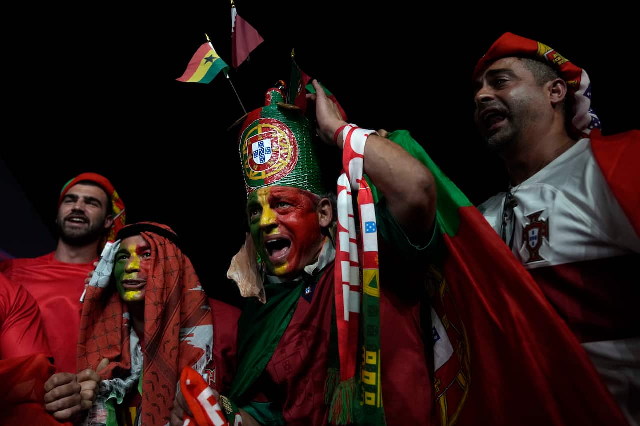 Portugal fans with red and green face paint and costumes