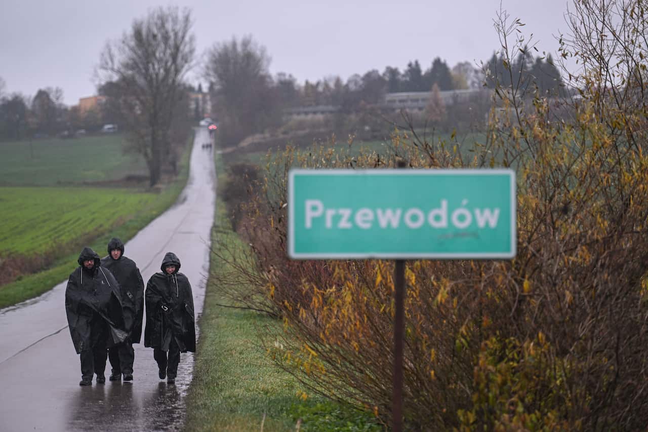 Police officers wear a rain coat as they search and patrol around the blast site on November 16, 2022 in Przewodow , Poland. 
