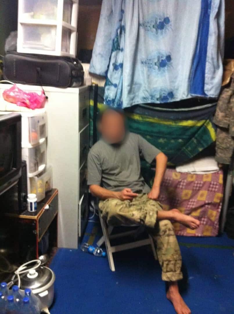 A man in army greens sits in a chair