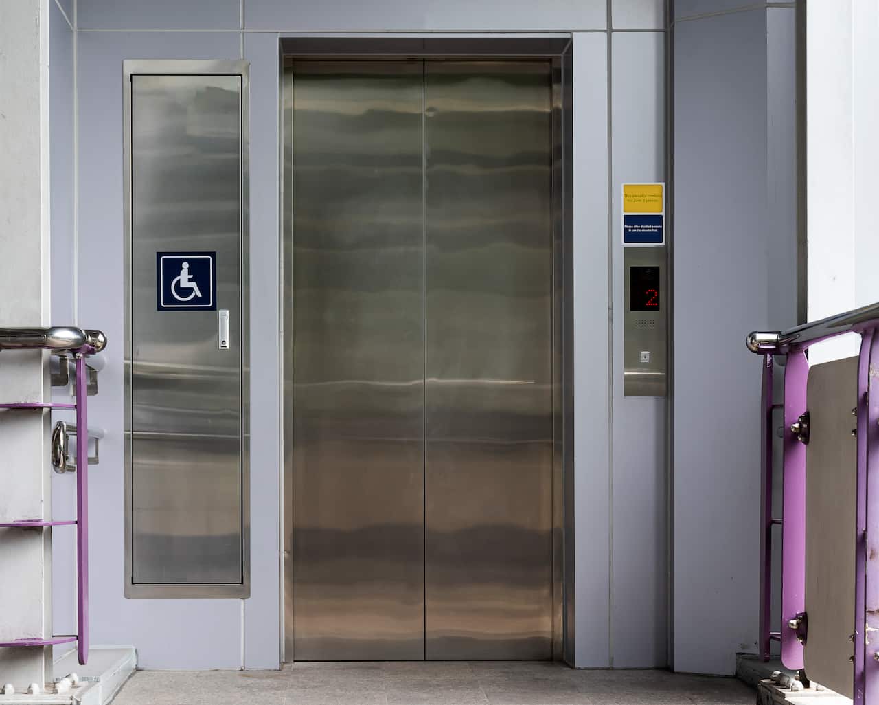 An elevator with a wheelchair sign next to it.