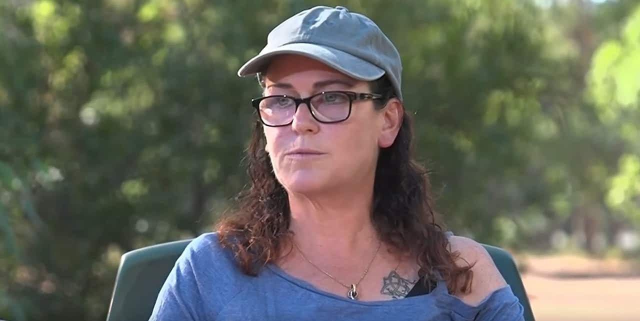 Woman with a hat and glasses in an interview.