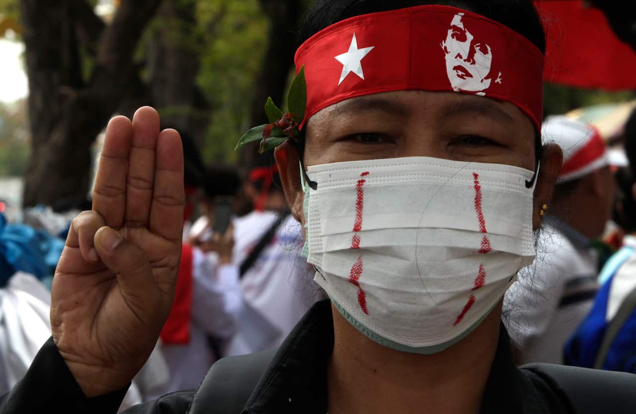 A person holds up three fingers in a salute.