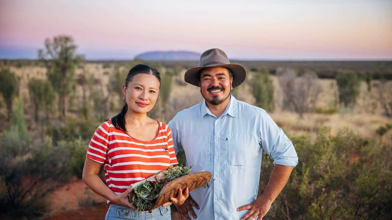 Poh Ling Yeow and Adam Liaw stand with Uluru in the background for their show Adam and Poh's Great Australian Bites.jpg