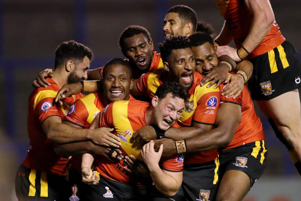 Rugby league players hug to celebrate a try