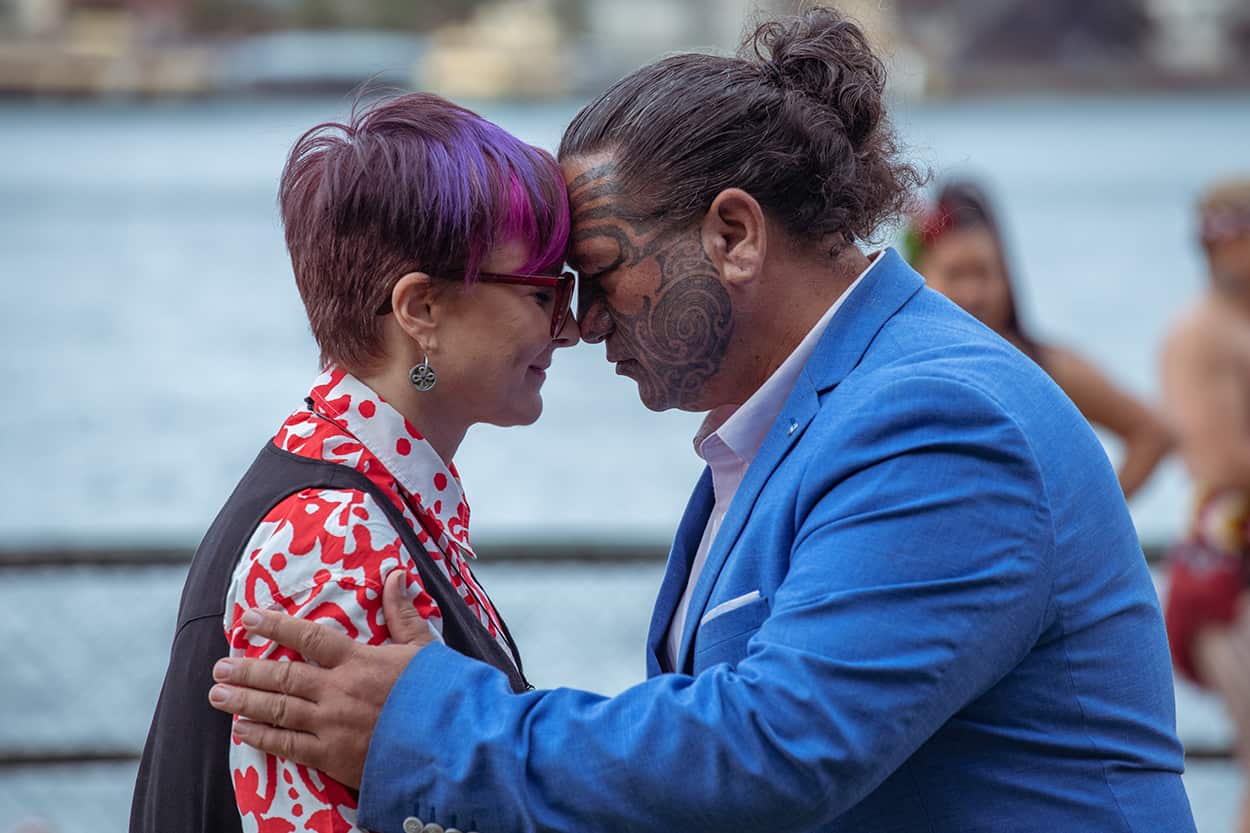 A man and woman meet in a traditional Maori greeting, touching forehead to forehead, in Sydney.jpg